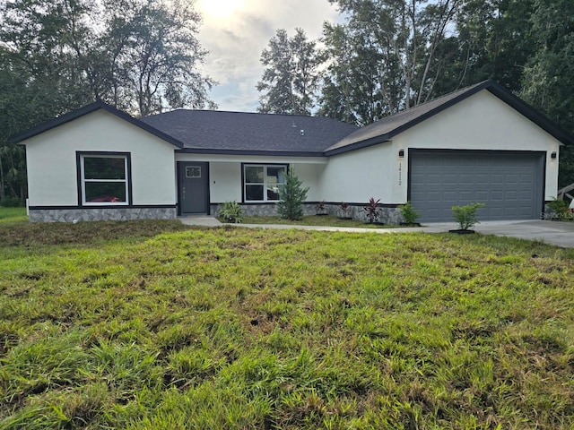 ranch-style house featuring a garage and a front yard