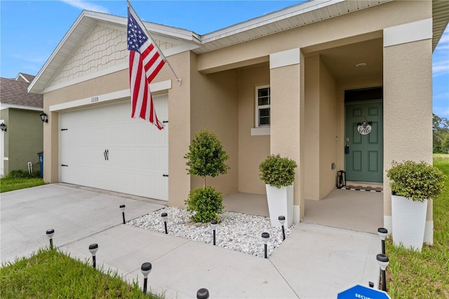 view of front facade with driveway, an attached garage, and stucco siding