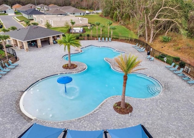 pool with a patio and fence