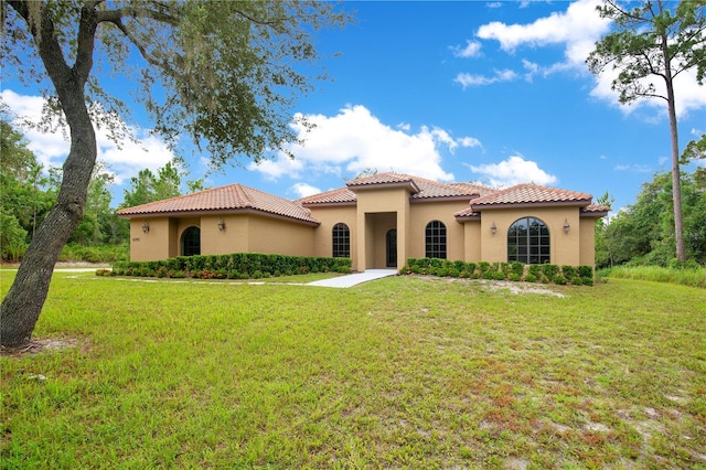 mediterranean / spanish home featuring a front lawn