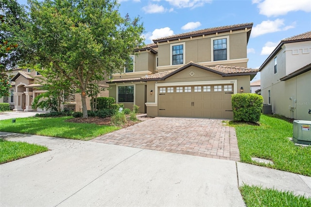 mediterranean / spanish-style house with a garage, central AC, and a front yard