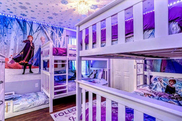 bedroom with a chandelier and hardwood / wood-style floors