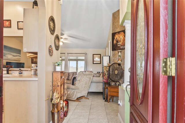 entrance foyer with light tile patterned flooring, ceiling fan, and vaulted ceiling