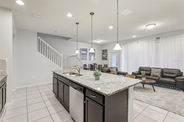 kitchen featuring light tile patterned flooring, pendant lighting, dishwasher, sink, and a center island with sink