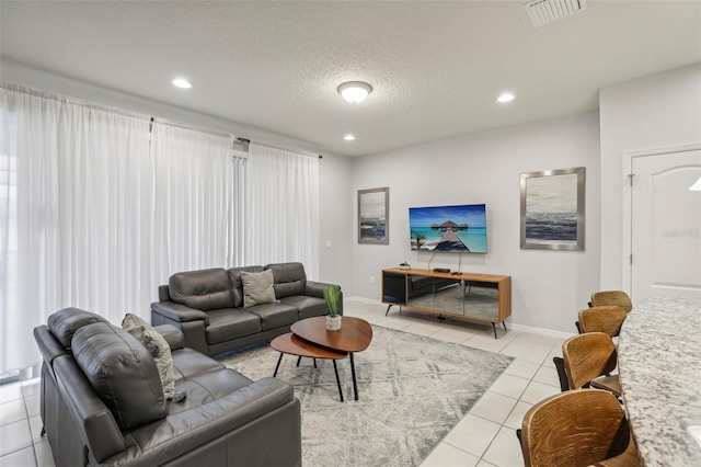 living room with light tile patterned flooring and a textured ceiling