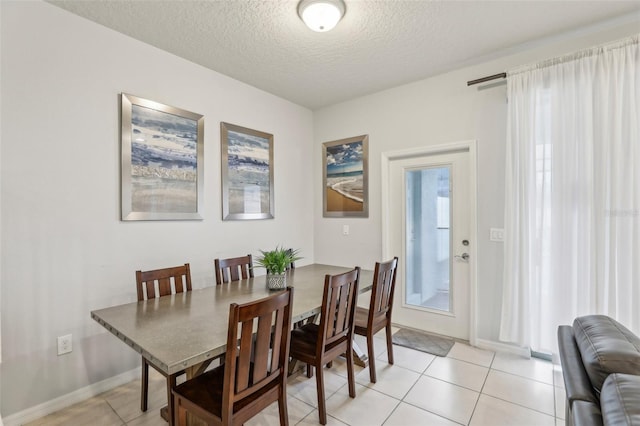 dining area with a textured ceiling and light tile patterned floors