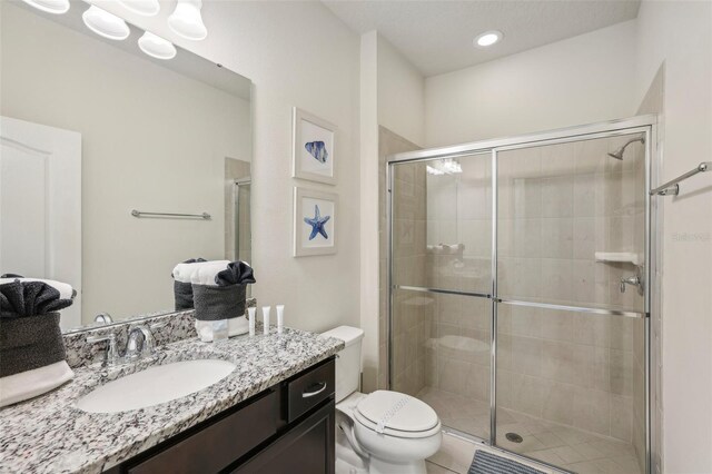 bathroom featuring toilet, vanity, and an enclosed shower