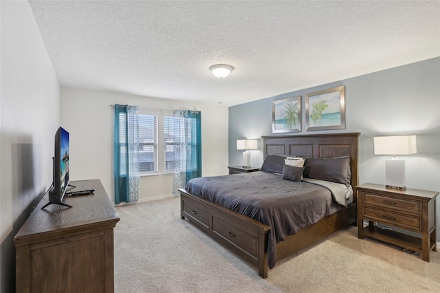 bedroom featuring light colored carpet and a textured ceiling