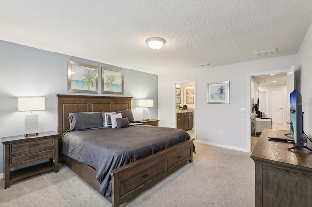 carpeted bedroom featuring a textured ceiling and ensuite bathroom