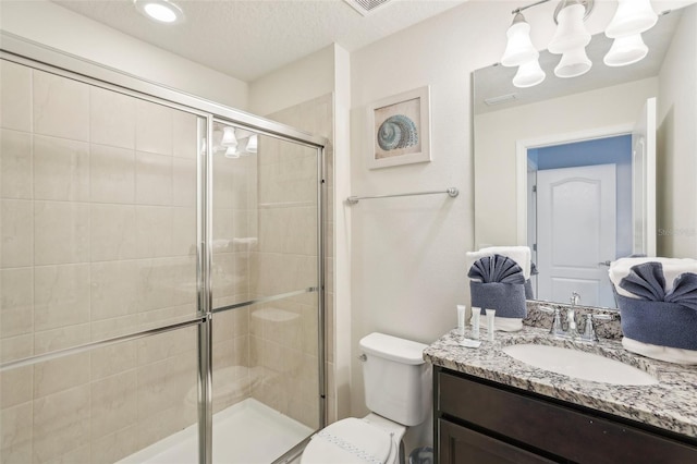 bathroom featuring a shower with door, a textured ceiling, vanity, and toilet