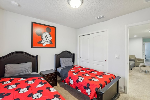 carpeted bedroom featuring a textured ceiling and a closet