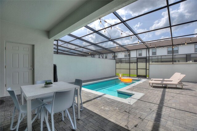 view of swimming pool featuring glass enclosure and a patio area