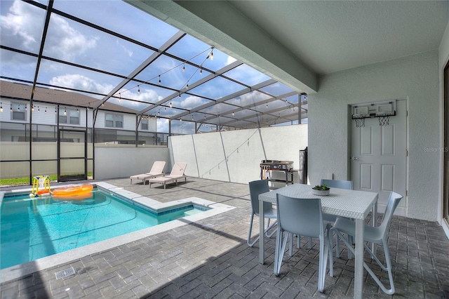 view of pool with glass enclosure and a patio area