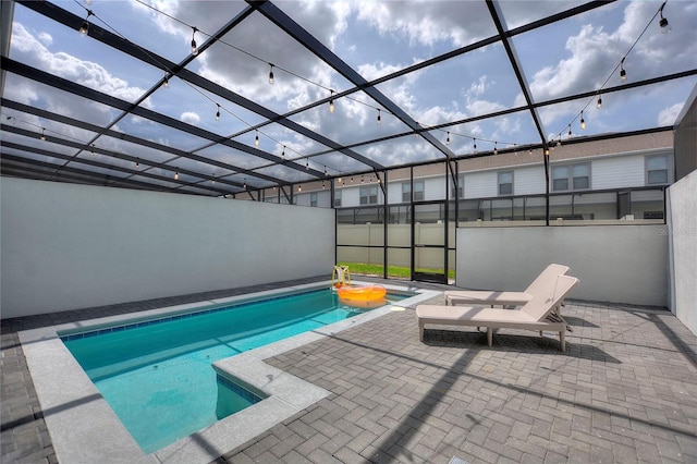 view of swimming pool featuring a patio and glass enclosure