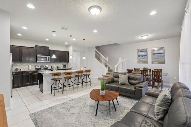 tiled living room featuring sink and a textured ceiling