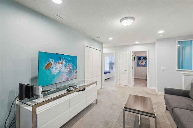 carpeted living room featuring a textured ceiling