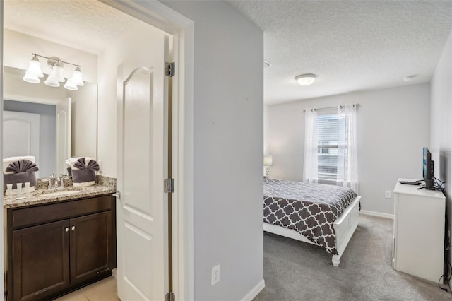 carpeted bedroom featuring sink and a textured ceiling