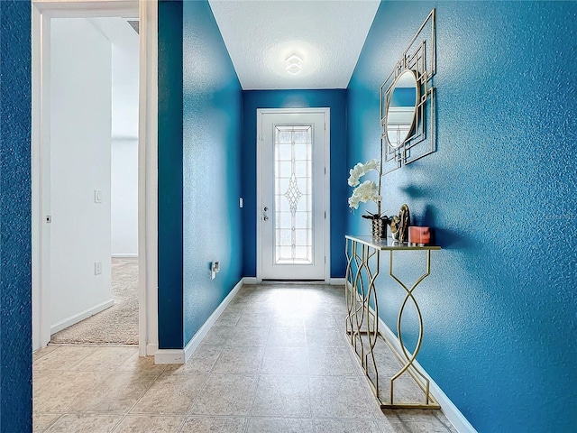 foyer featuring carpet and a textured ceiling