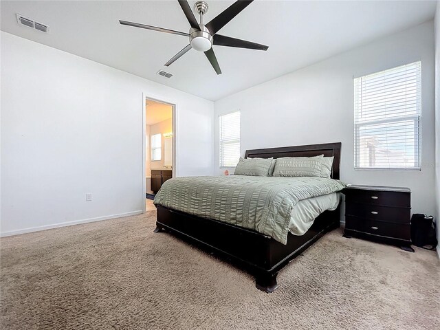 bedroom with carpet, ceiling fan, and connected bathroom