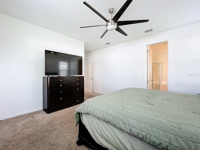 carpeted bedroom with ensuite bath and ceiling fan