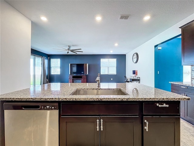 kitchen featuring dishwasher, dark brown cabinets, a kitchen island with sink, and sink