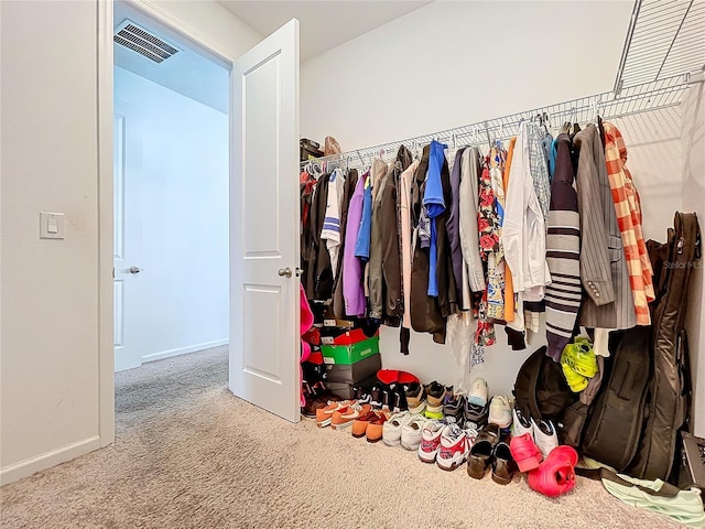 walk in closet featuring light carpet