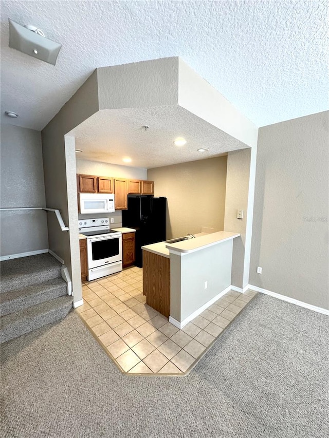 kitchen featuring light carpet, a textured ceiling, kitchen peninsula, and white appliances