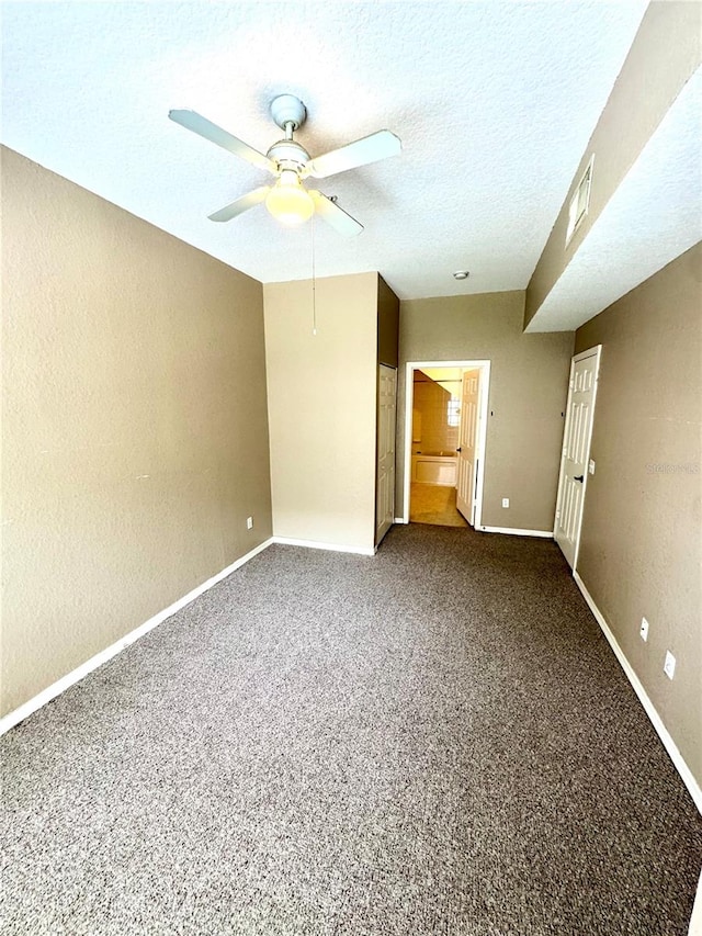 unfurnished bedroom featuring a textured ceiling, carpet floors, and ceiling fan