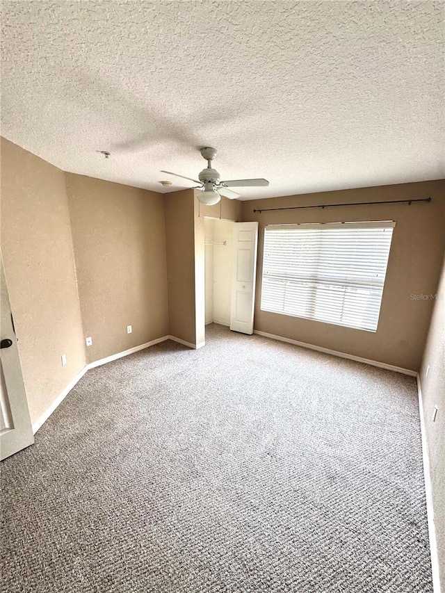 unfurnished room featuring light carpet, ceiling fan, and a textured ceiling