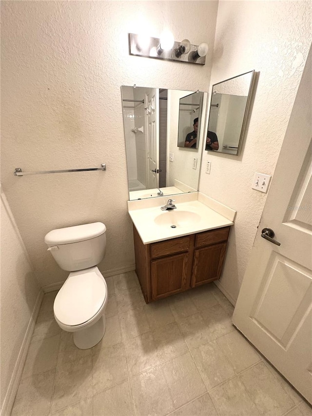 bathroom with vanity, tile patterned flooring, and toilet