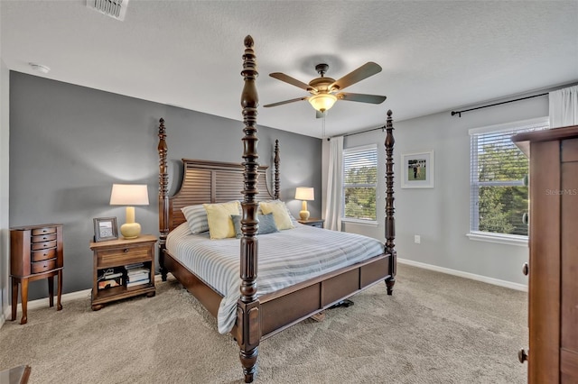 bedroom featuring ceiling fan, light carpet, and a textured ceiling