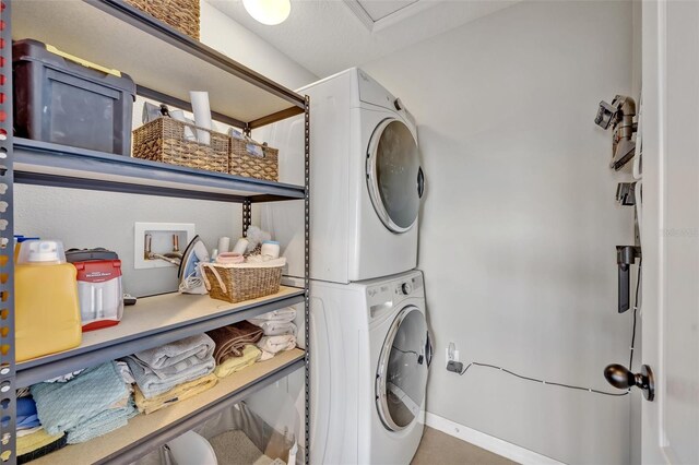 laundry area featuring stacked washer / drying machine