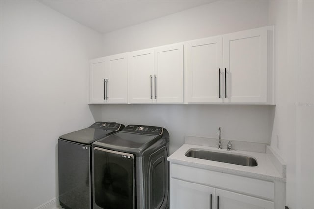 laundry room with sink, washer and clothes dryer, and cabinets