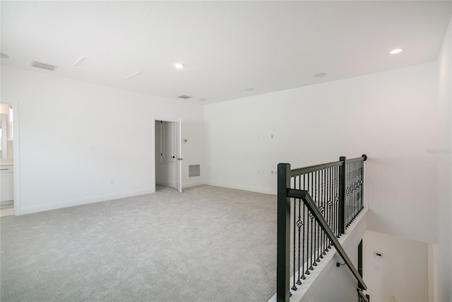 unfurnished room featuring light carpet