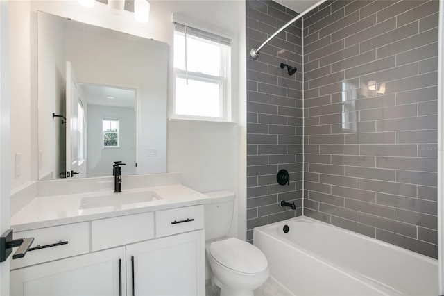 full bathroom featuring tiled shower / bath, vanity, and toilet