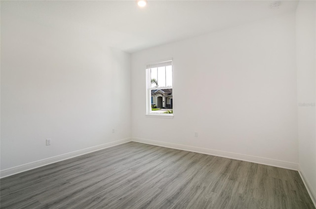 unfurnished room with dark wood-type flooring