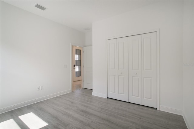 unfurnished bedroom with a closet and light hardwood / wood-style flooring