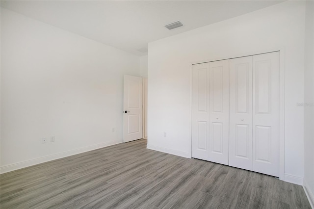 unfurnished bedroom with a closet and light hardwood / wood-style flooring