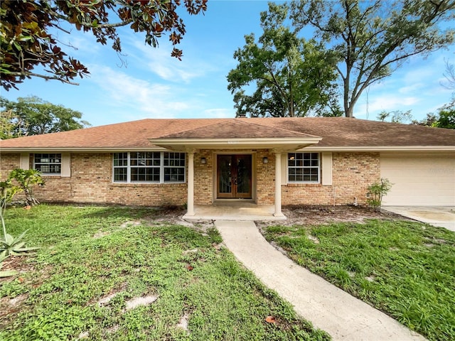 ranch-style home with a garage and a front lawn