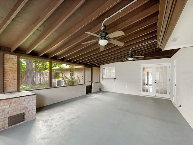 unfurnished sunroom featuring a fireplace, french doors, ceiling fan, and a healthy amount of sunlight