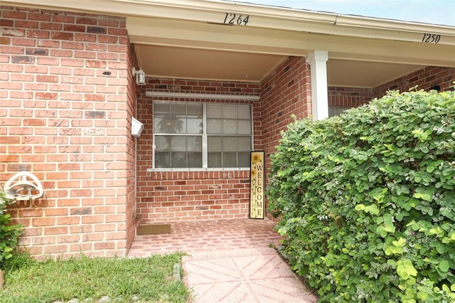 doorway to property featuring brick siding