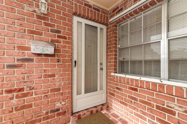 doorway to property with brick siding