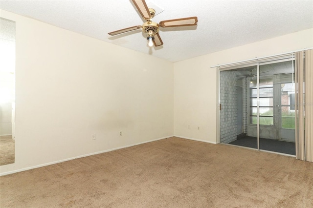 spare room with carpet flooring, ceiling fan, a textured ceiling, and baseboards