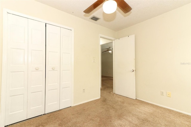 unfurnished bedroom with baseboards, visible vents, a closet, and light colored carpet