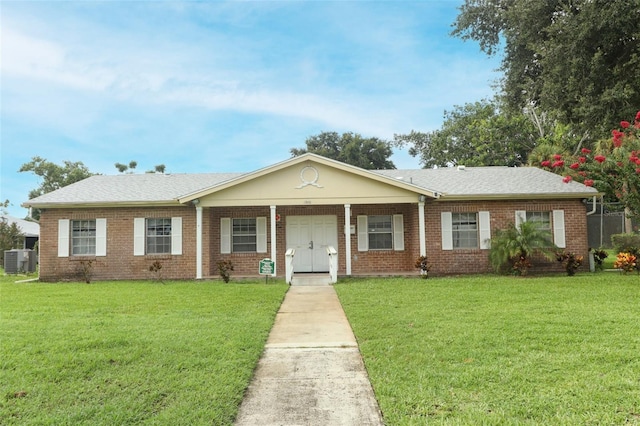 ranch-style home featuring a shingled roof, central AC unit, a front lawn, and brick siding