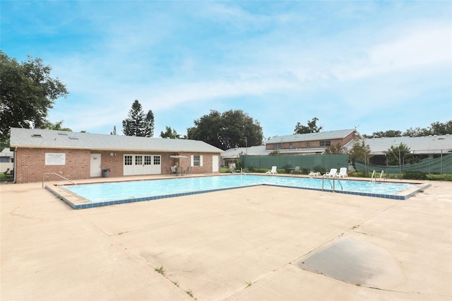 community pool featuring a patio area and fence