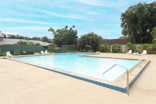 community pool with fence and a patio