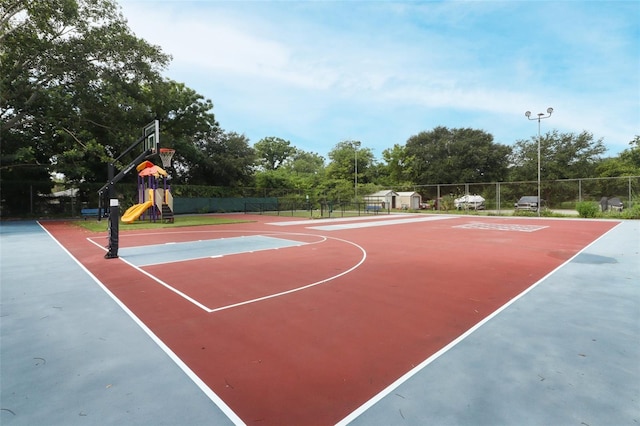 view of sport court with community basketball court, fence, and playground community