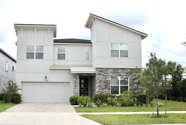 contemporary home with a garage and a front yard