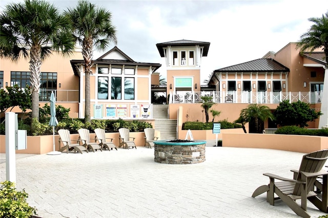 exterior space with a balcony and a fire pit